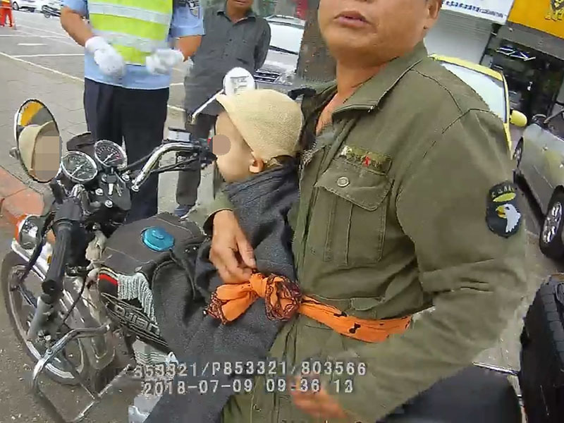 騎摩托車男子僅用一根布條將小男孩固定在自己身上,，行駛在馬路上 (2)