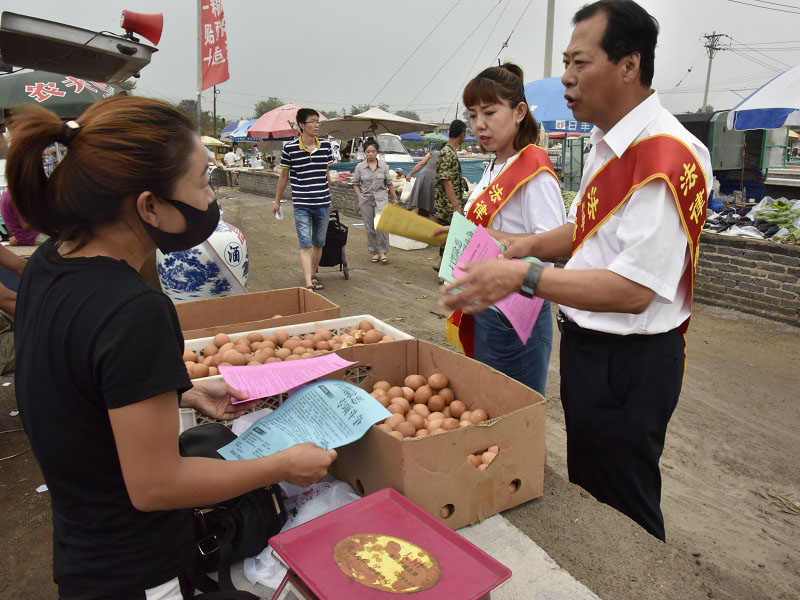 1錦州市委政法委政治部主任,、市掃黑辦宣傳組組長李偉(右一)走進集市進行普法宣傳