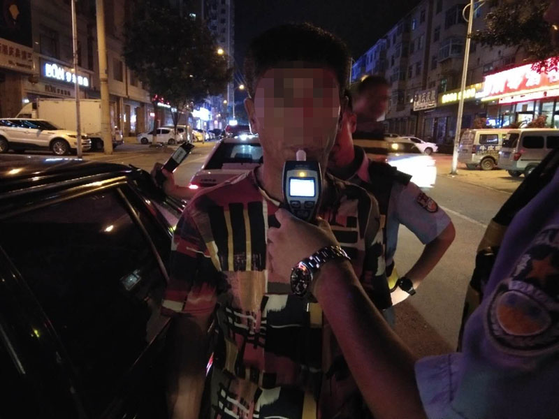 交警對駕駛員進行酒精測試
