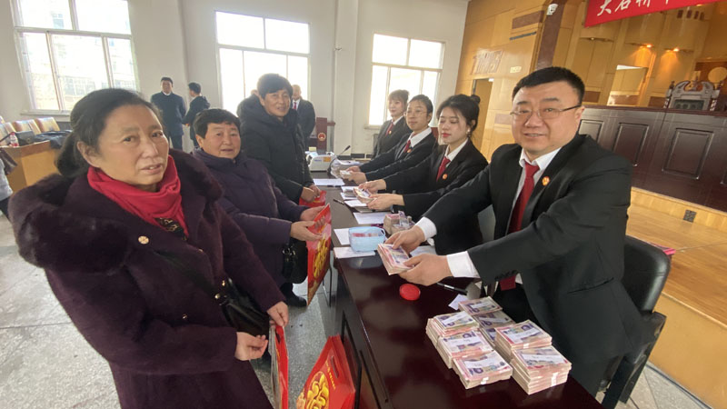 徐斌（左二）領取工資款,；右一是大石橋市人民法院執(zhí)行員王敬偉