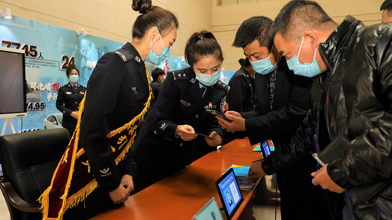 民警指導(dǎo)市民掃碼登錄“交管12123”APP,。