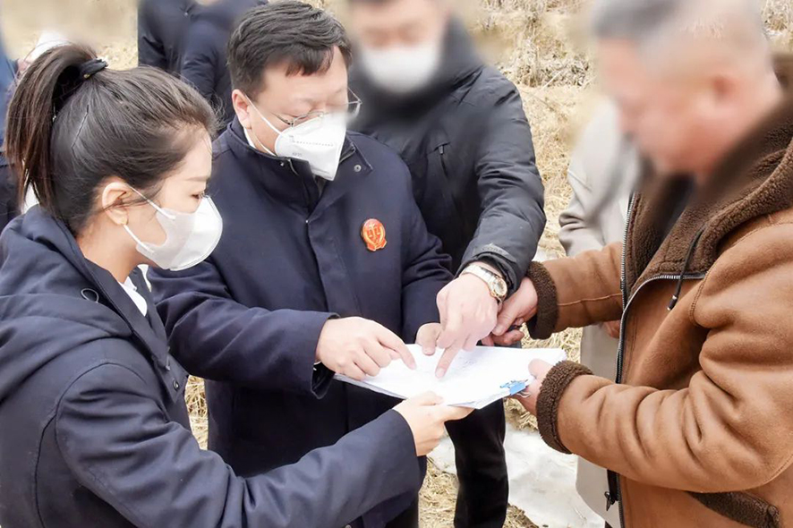 新民市法院大民屯法庭庭長王旌棘（左二）與委托代理人,、村委會干部核對土地面積——馬震宇攝