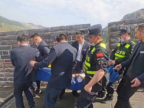 民警與景區(qū)工作人員將患病游客抬下長城,。