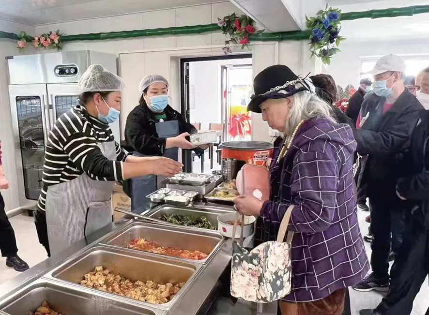 配文1：社區(qū)居民在食堂打飯,。