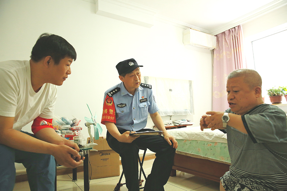 臨退休前,，社區(qū)民警王忠利（左二）和網格員去劉學成家中走訪