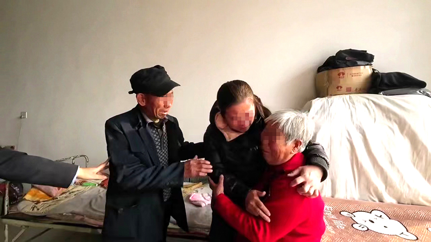 “肚兜女嬰”王麗（中）與父母團(tuán)圓,。