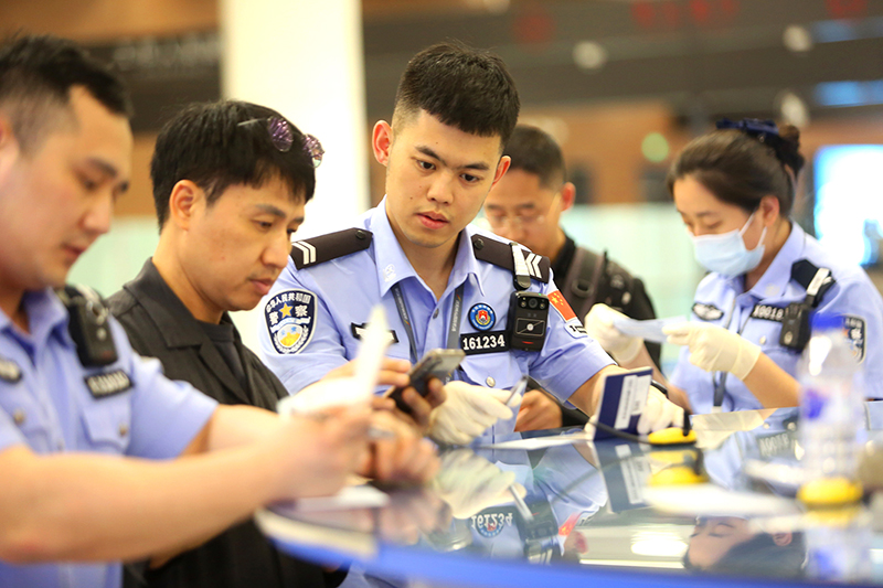 民警協(xié)助外國(guó)旅客填寫入境卡片。