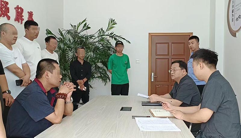 新民市法院執(zhí)行局局長王旌棘（右3）向農(nóng)民工們了解案情（所有不穿法服和警服的人,，都需要馬賽克!）