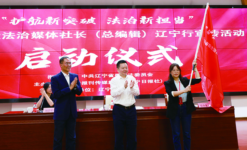 遼寧報(bào)刊傳媒集團(tuán)（遼寧日報(bào)社）黨委副書記,、總編輯張小龍（右二）,，遼寧省委政法委副書記米德龍（右三）向采訪團(tuán)代表授旗