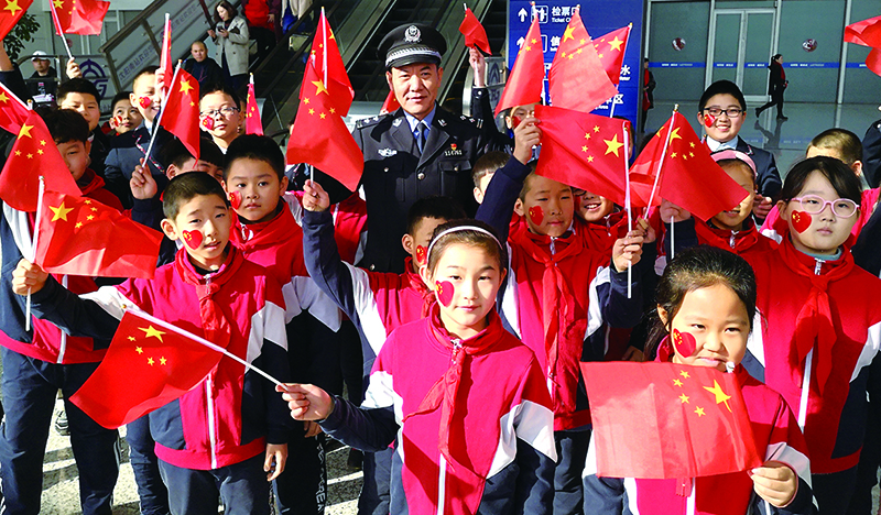 全國公安系統(tǒng)二級英雄模范沈陽市公安局蘇家屯分局民警李春和與轄區(qū)學校的孩子們?yōu)樽鎳鴳c生