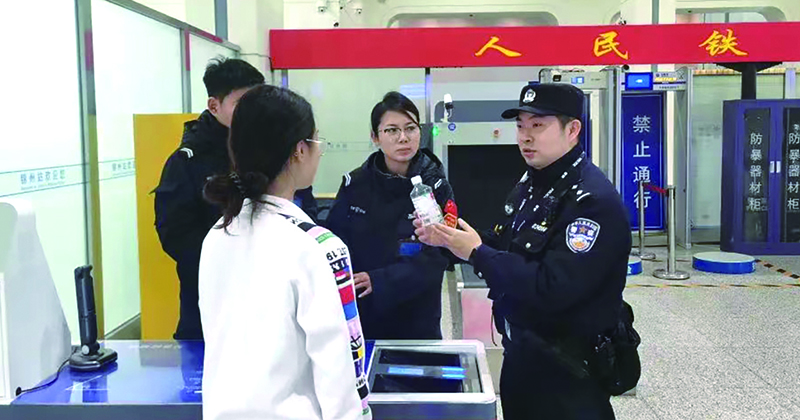 二題圖,，童秋華（右）在向旅客講解安檢規(guī)定