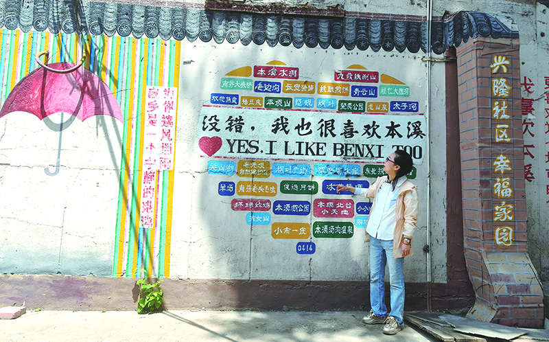 楊軼達向記者介紹社區(qū)的墻繪。