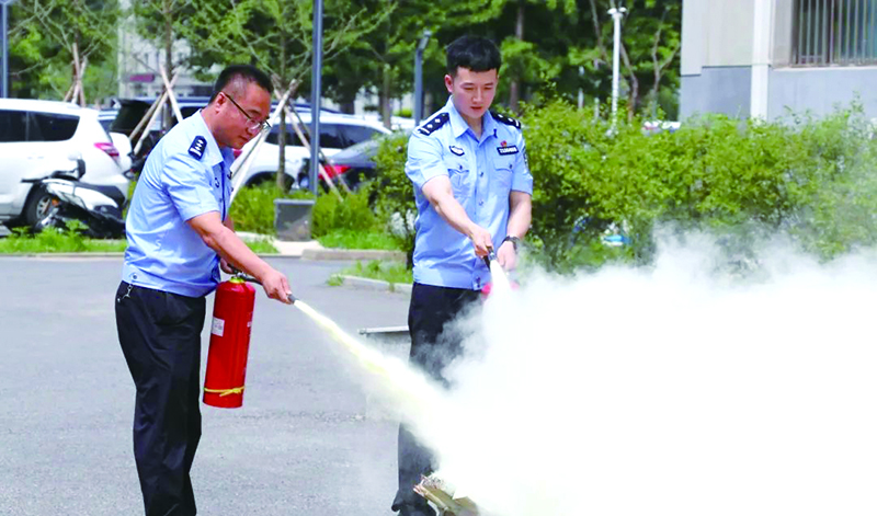 二題圖,，民警進(jìn)行滅火器撲救初期火災(zāi)實(shí)操演練。